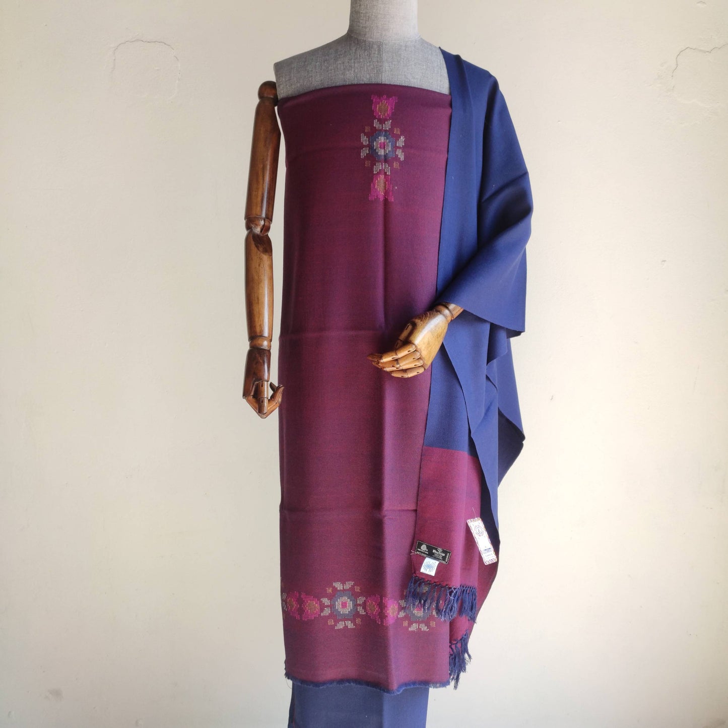 Mannequin wearing a maroon and blue traditional women's woolen suit with embroidery 