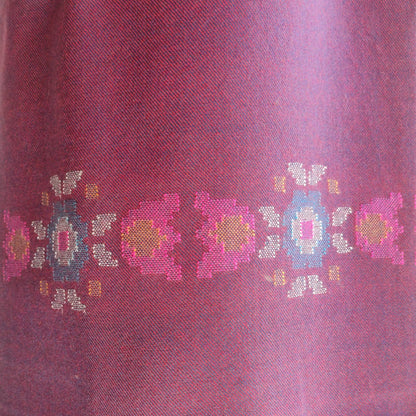 Close-up of a women's woolen suit with embroidered floral patterns
