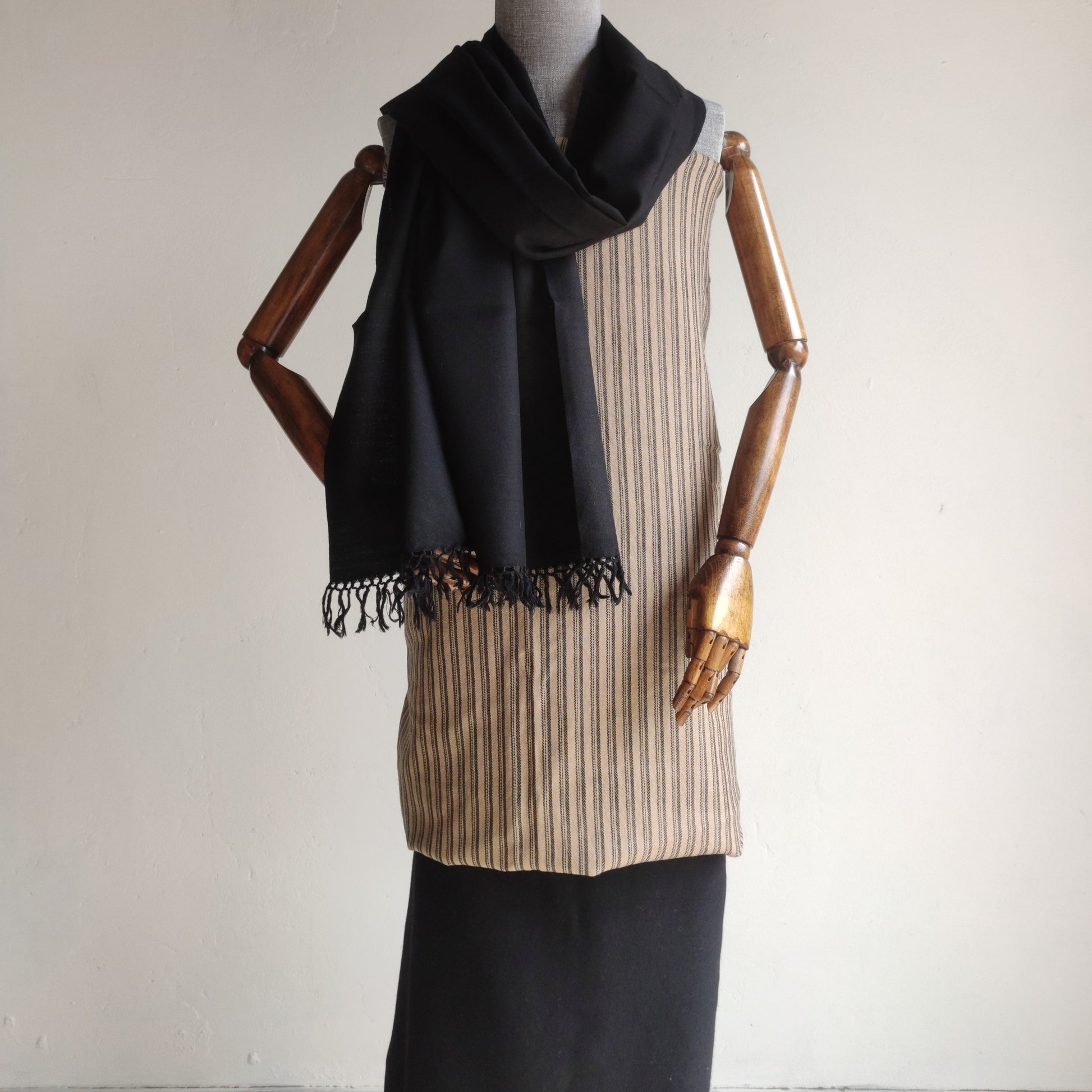Mannequin wearing a black scarf and beige striped women's woolen suit