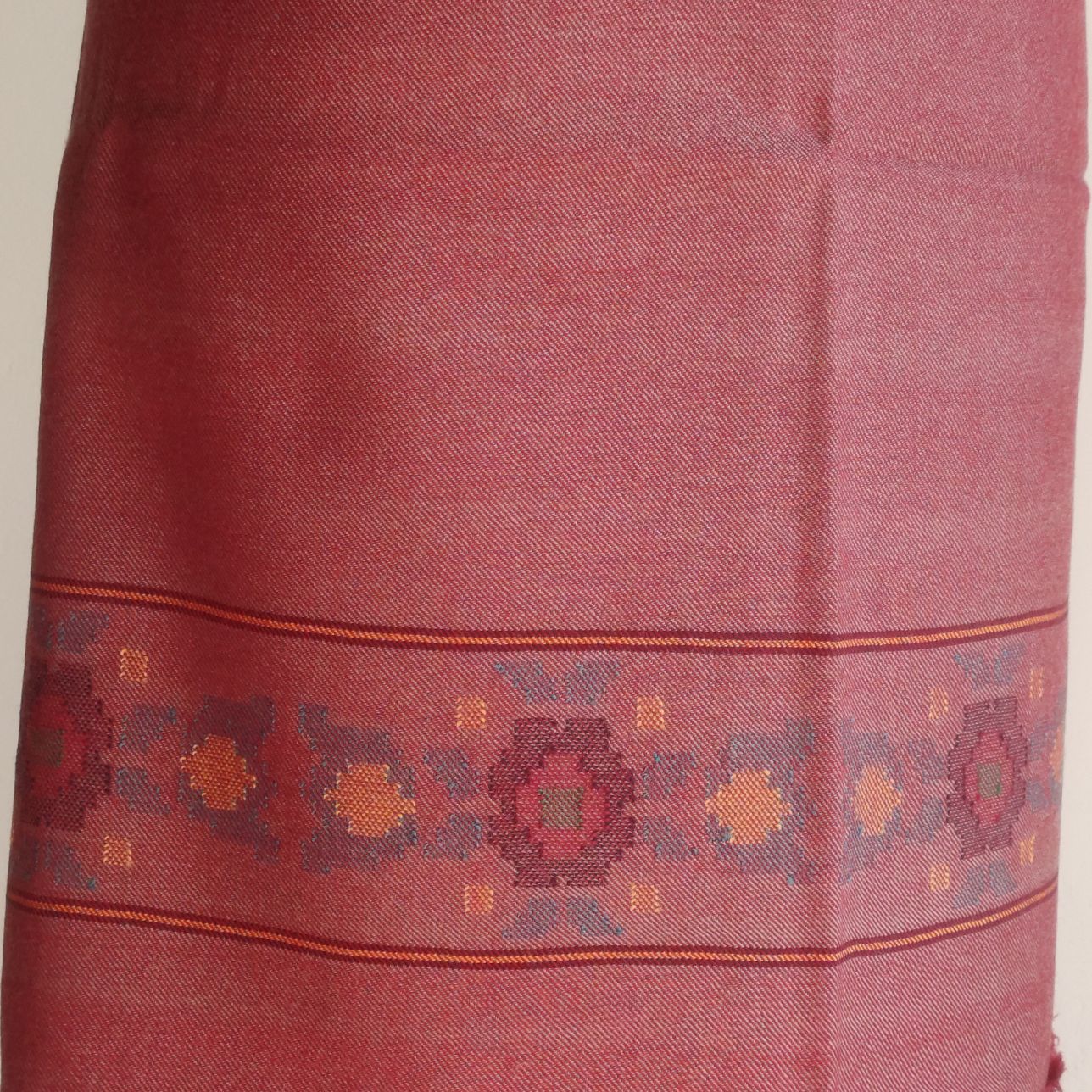 Close-up of a red suit with intricate patterns on a plain background